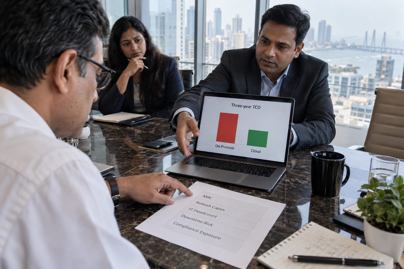 CFO and COO reviewing a five-line-item on-premise cost spreadsheet in a Mumbai boardroom with TCO chart on laptop